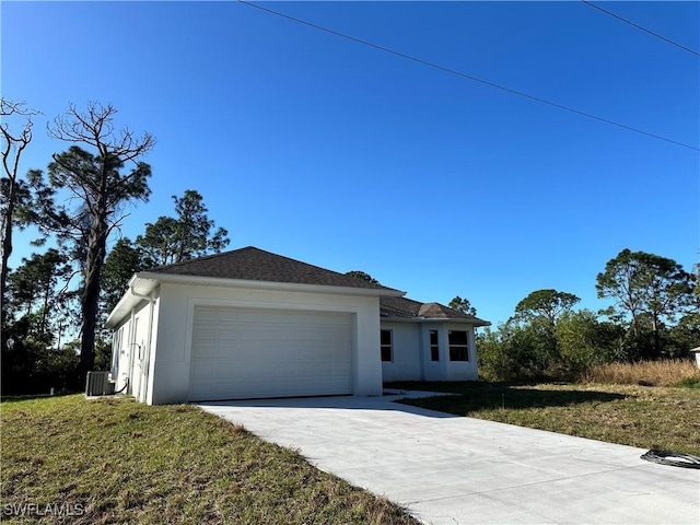 view of front of property featuring a garage, a front lawn, and central air condition unit