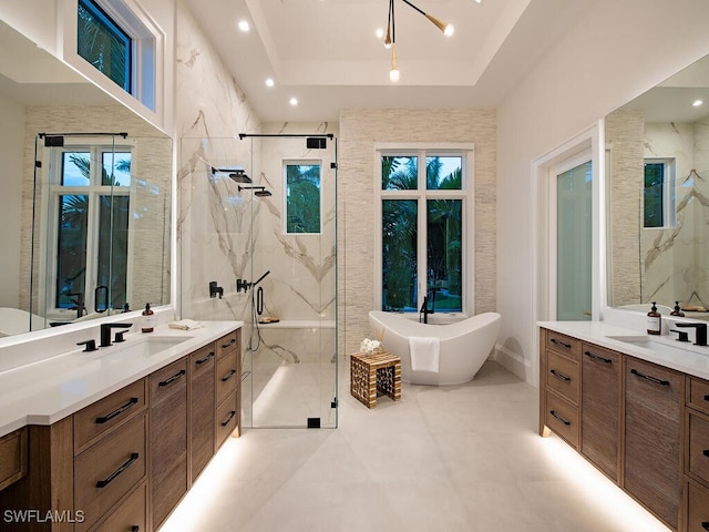 bathroom featuring a raised ceiling, vanity, and shower with separate bathtub