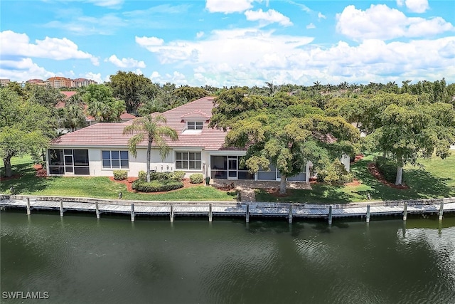 back of house with a sunroom, a yard, and a water view