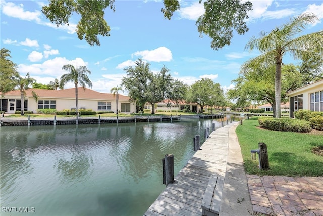 view of dock with a yard and a water view