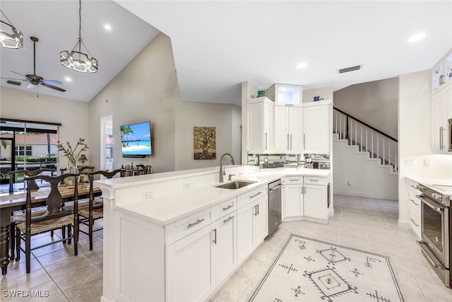 kitchen with white cabinets, sink, hanging light fixtures, kitchen peninsula, and stainless steel appliances