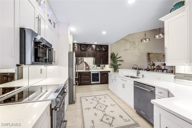 kitchen featuring pendant lighting, sink, appliances with stainless steel finishes, light tile patterned flooring, and white cabinetry