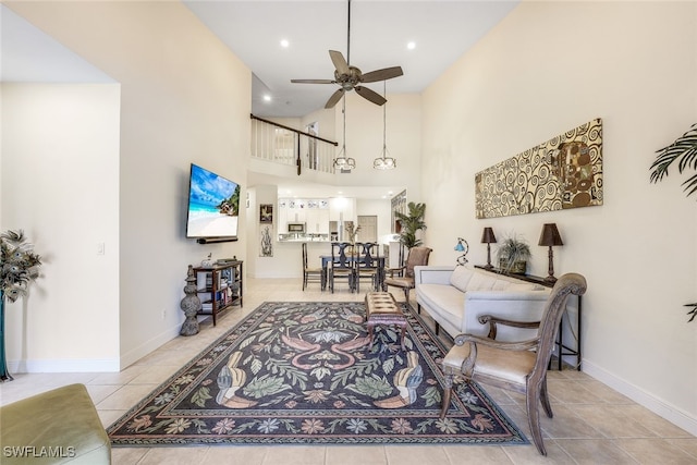 tiled living room featuring ceiling fan and a high ceiling