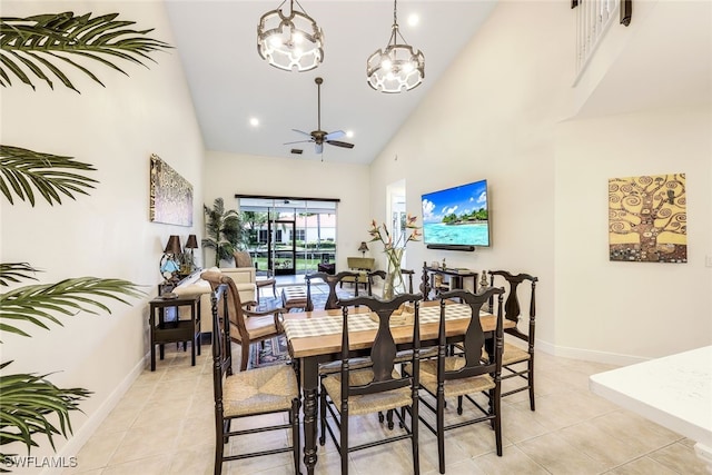 tiled dining area featuring ceiling fan with notable chandelier and high vaulted ceiling