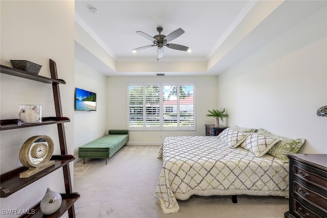 carpeted bedroom featuring a raised ceiling, ceiling fan, and ornamental molding