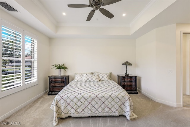 carpeted bedroom with a raised ceiling, ceiling fan, and ornamental molding