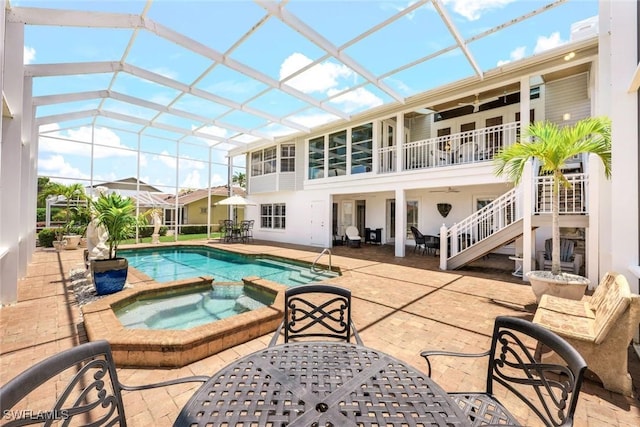 back of house featuring a pool with hot tub, a patio, and glass enclosure