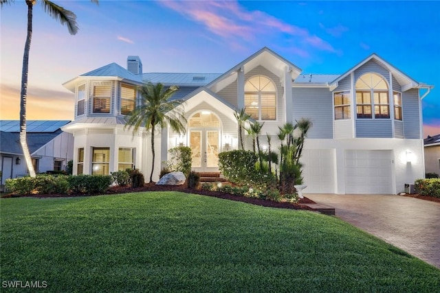 view of front of home featuring a garage and a lawn