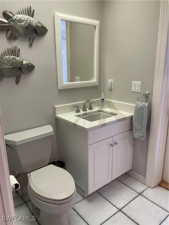 bathroom with tile patterned flooring, vanity, and toilet