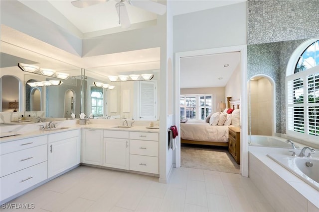 bathroom with vanity, a relaxing tiled tub, tile patterned floors, and ceiling fan