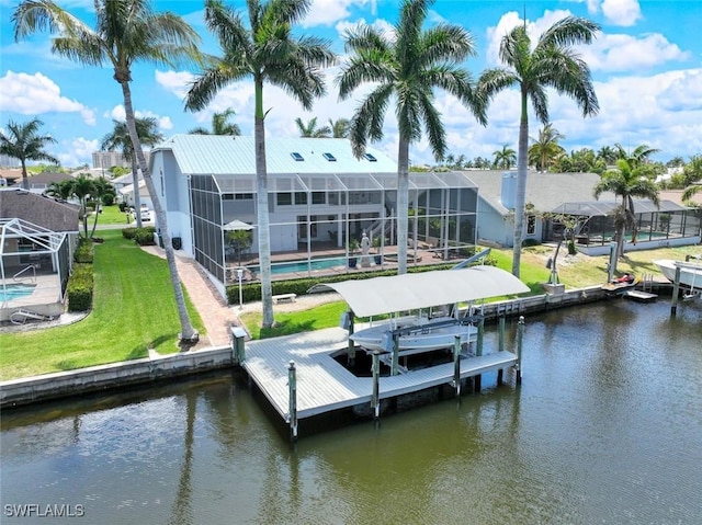 view of dock with a water view, glass enclosure, and a lawn