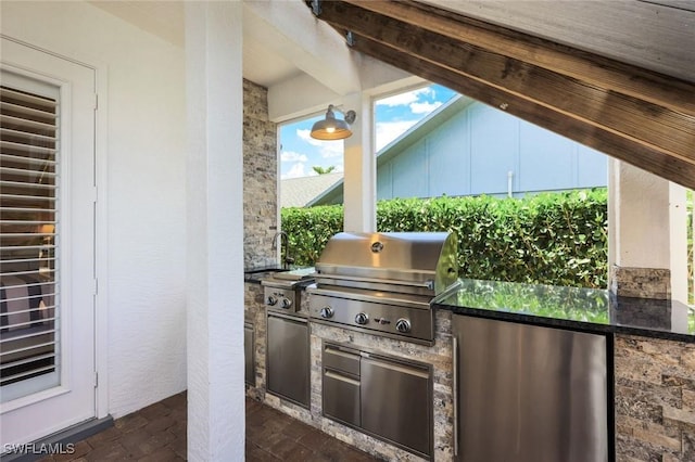 view of patio featuring exterior kitchen, area for grilling, and sink