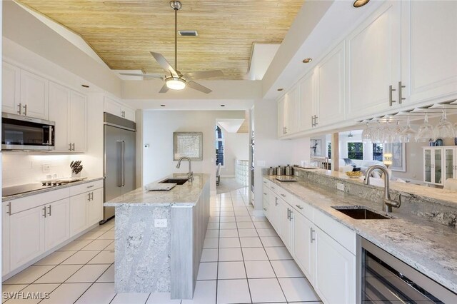 kitchen featuring stainless steel appliances, white cabinetry, wooden ceiling, and beverage cooler