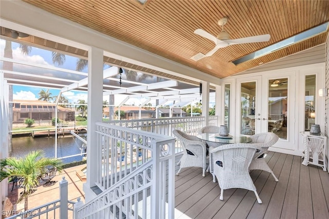 sunroom featuring vaulted ceiling, a water view, ceiling fan, and wood ceiling