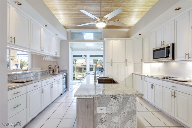 kitchen featuring white cabinets, sink, a center island with sink, and wooden ceiling