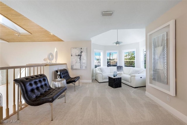 living area with a skylight, light colored carpet, and wooden ceiling