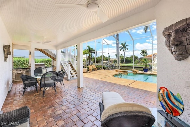 view of patio / terrace featuring a pool with hot tub, ceiling fan, and glass enclosure