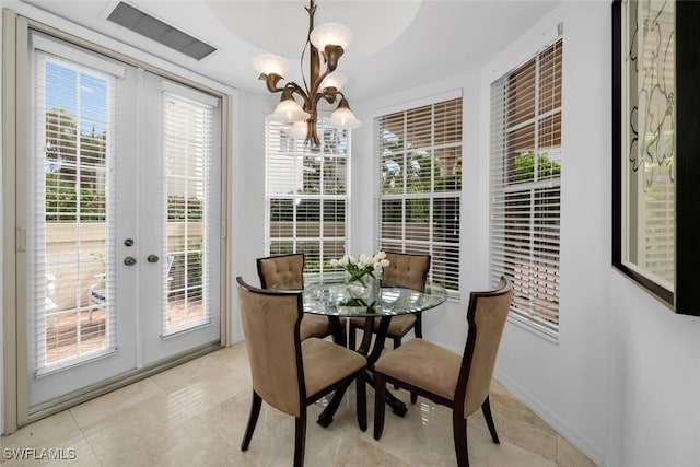 dining area featuring a wealth of natural light, french doors, light tile patterned flooring, and an inviting chandelier