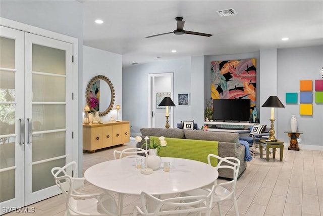 dining space featuring french doors, ceiling fan, and light wood-type flooring