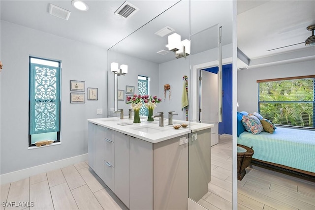 bathroom featuring vanity and ceiling fan with notable chandelier