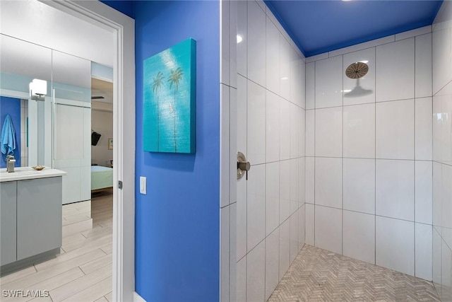 bathroom with hardwood / wood-style flooring and tiled shower