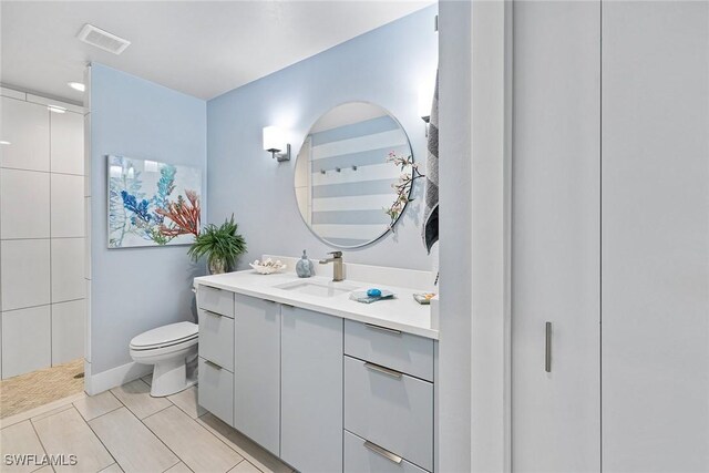 bathroom featuring walk in shower, tile patterned flooring, vanity, and toilet