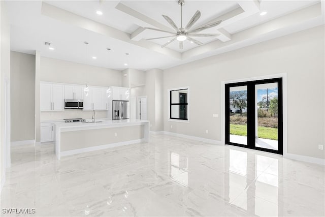 unfurnished living room featuring ceiling fan, a towering ceiling, sink, and coffered ceiling