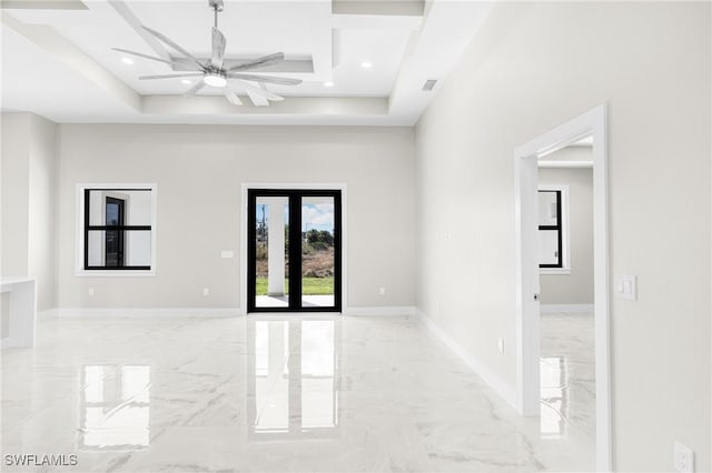 spare room with ceiling fan and a tray ceiling