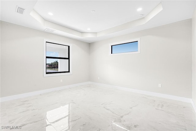 empty room featuring a raised ceiling