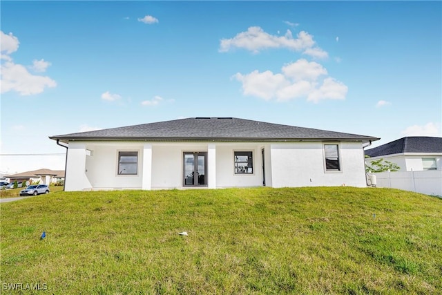 rear view of property featuring french doors and a lawn