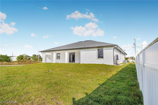 back of house with a lawn