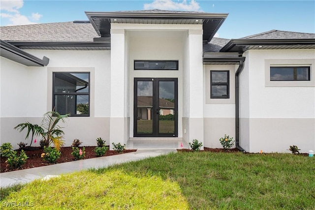 entrance to property with french doors and a yard