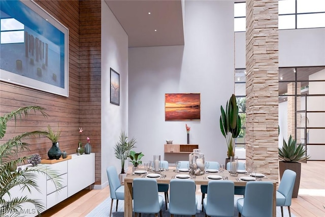 dining area featuring light hardwood / wood-style floors and a high ceiling