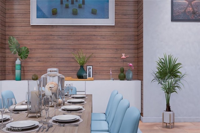 dining area with hardwood / wood-style flooring and wood walls