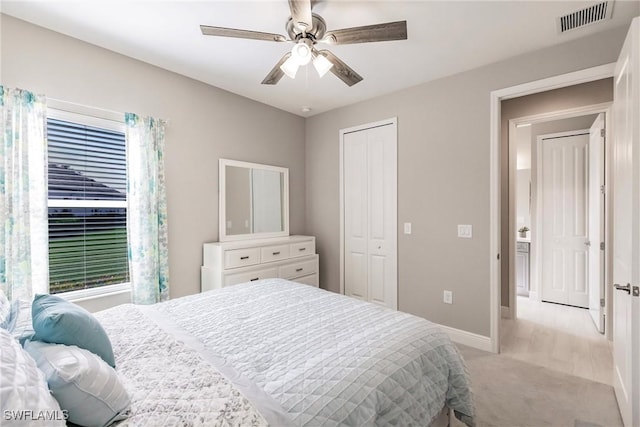 bedroom with multiple windows, light carpet, a closet, and ceiling fan