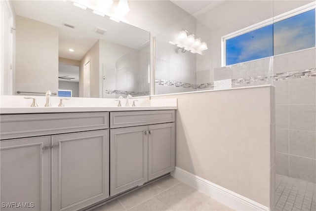 bathroom with tile patterned floors, vanity, ceiling fan, and tiled shower