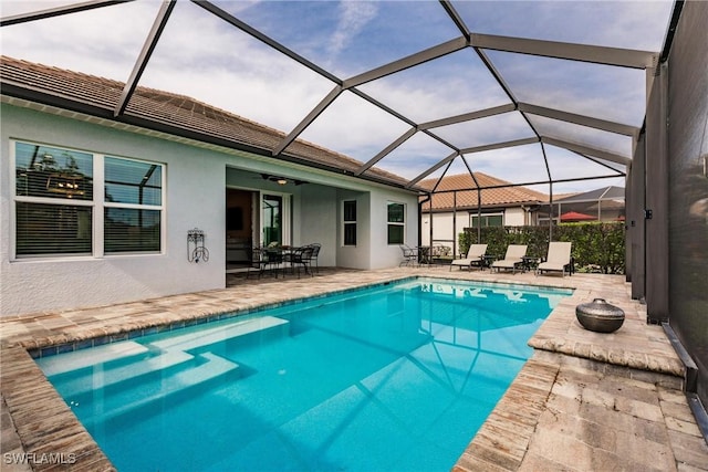 view of swimming pool featuring a lanai, a patio area, and ceiling fan