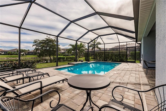 view of pool featuring glass enclosure and a patio area