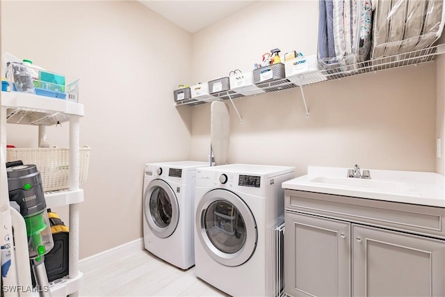 laundry room with washer and clothes dryer, sink, and cabinets