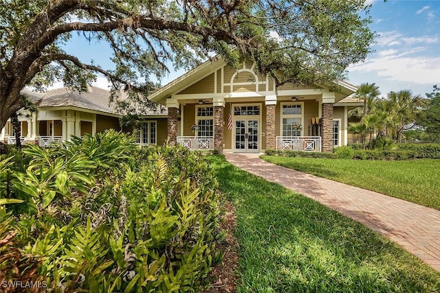 craftsman house with french doors, a front lawn, and a porch