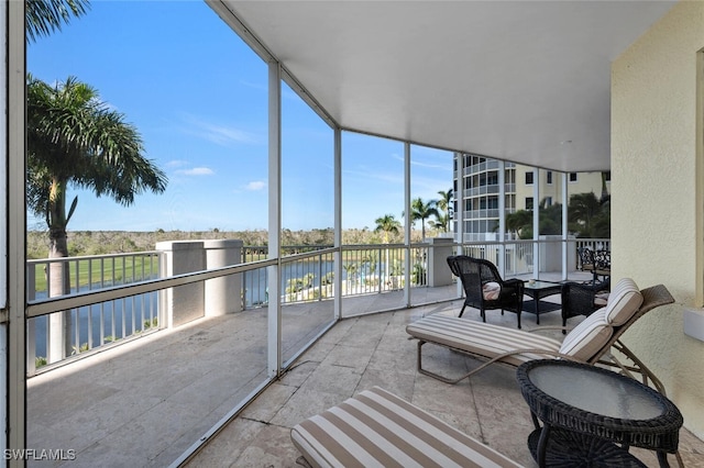 sunroom with a water view and a healthy amount of sunlight