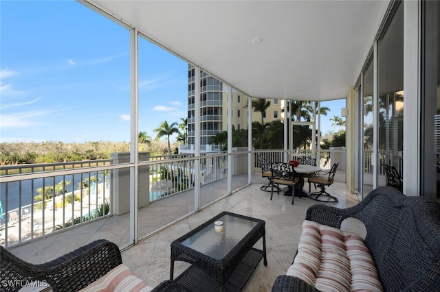 sunroom featuring a water view