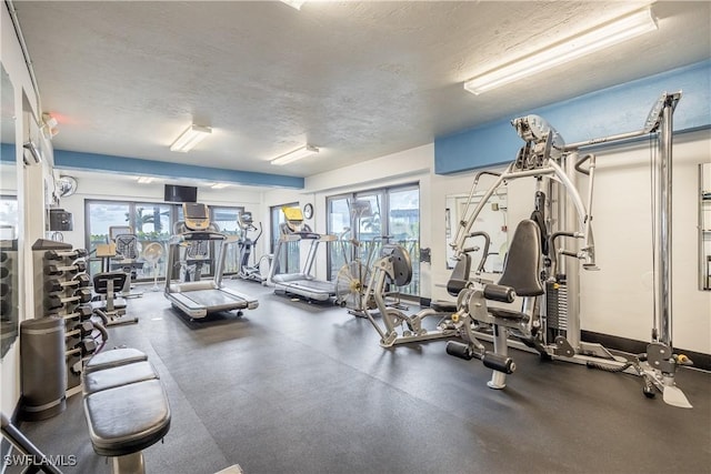 gym with plenty of natural light and a textured ceiling