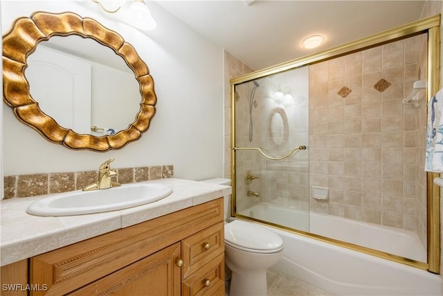 bathroom with toilet, tile patterned floors, enclosed tub / shower combo, and vanity