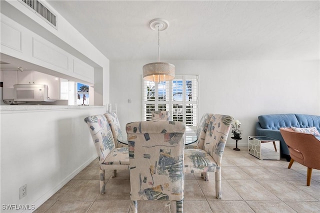 dining area featuring light tile patterned floors, baseboards, and visible vents