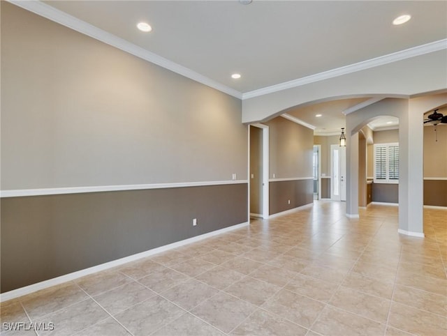 empty room featuring ceiling fan, light tile patterned flooring, and crown molding