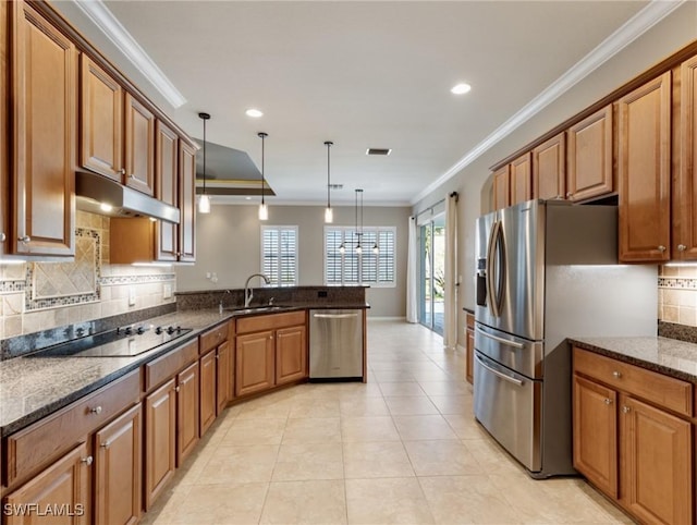 kitchen featuring appliances with stainless steel finishes, decorative light fixtures, dark stone countertops, ornamental molding, and kitchen peninsula