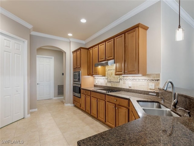 kitchen with appliances with stainless steel finishes, backsplash, pendant lighting, crown molding, and sink