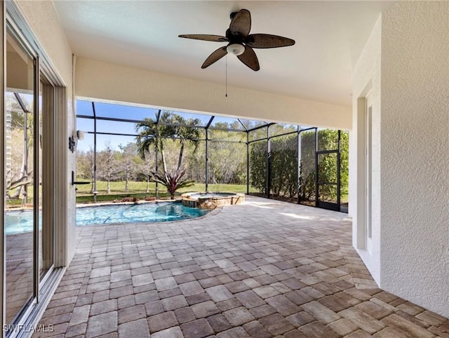 view of pool with ceiling fan, an in ground hot tub, pool water feature, glass enclosure, and a patio