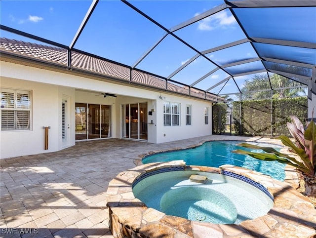 view of pool with ceiling fan, glass enclosure, an in ground hot tub, and a patio